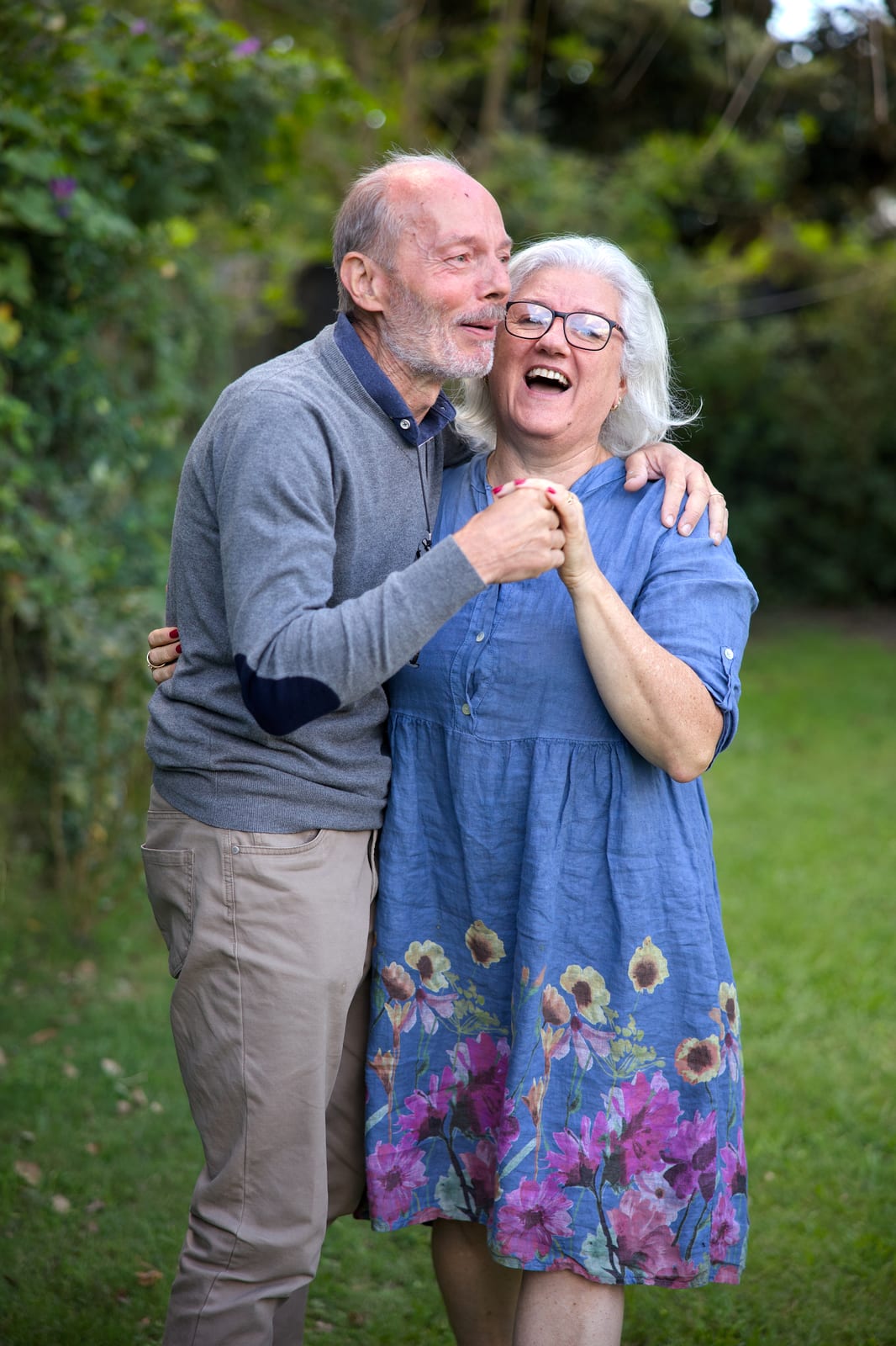 Pablo's parents smiling and dancing together in a green garden